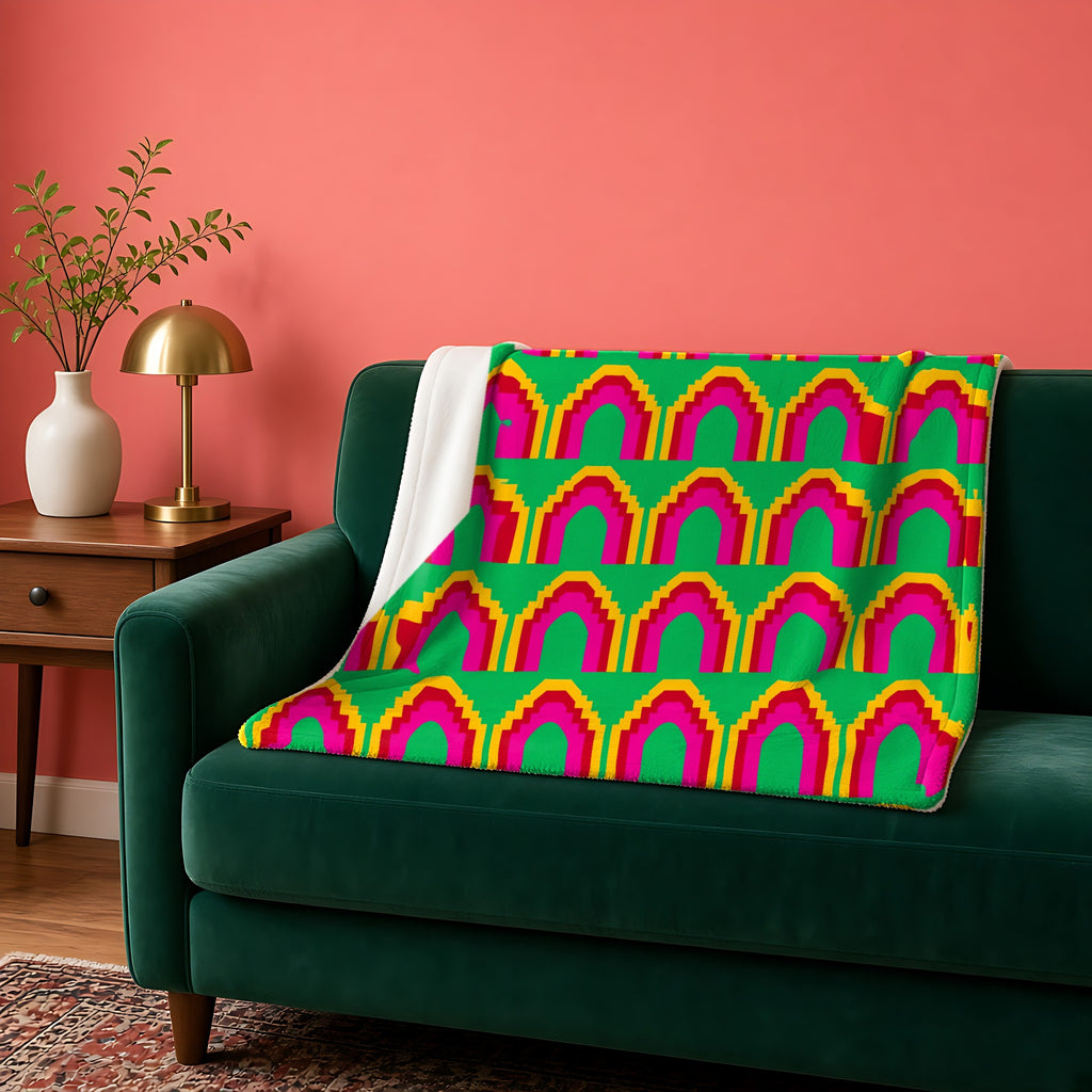 Grand Stepped Arches sherpa fleece blanket in the Christmas Jewel Bright palette, draped over a green sofa against a coral wall