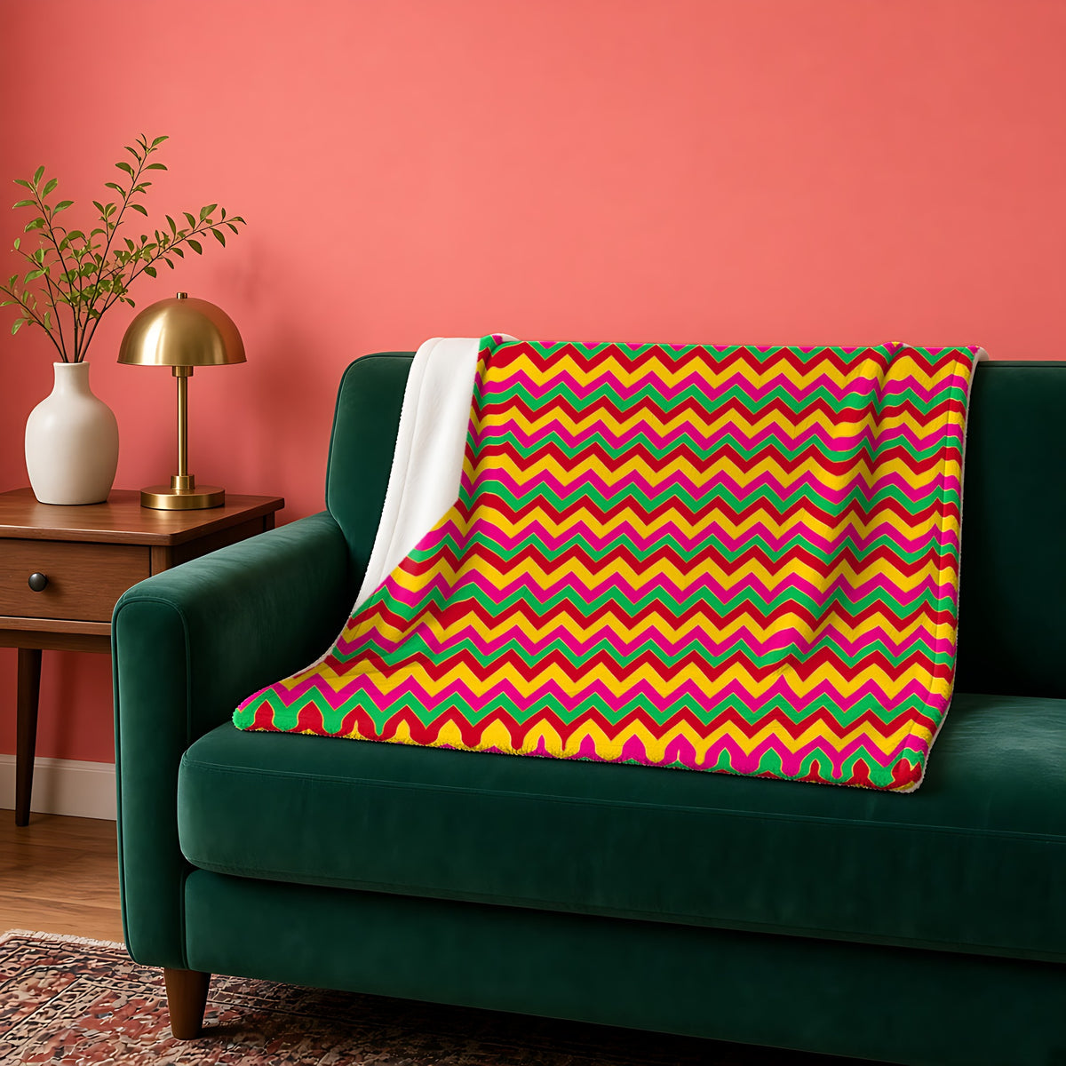 Jewel Chevron Bands sherpa fleece blanket in the Festive Jewel Bright palette, draped over a green sofa against a coral wall