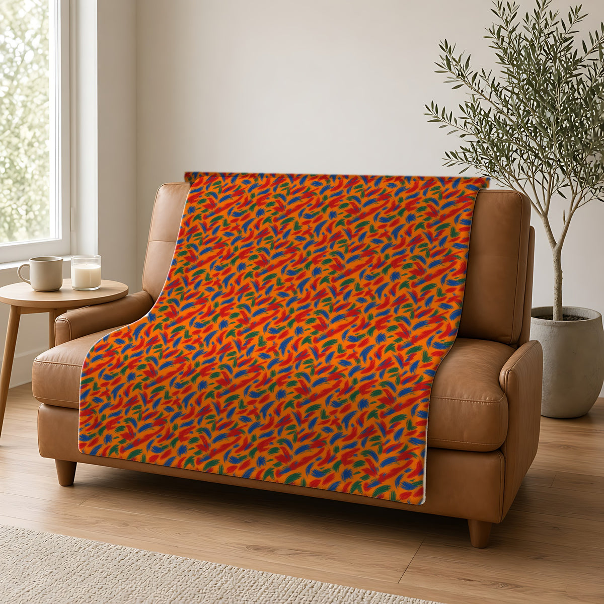 Layered Gesture Scribbles Sherpa Fleece Blanket draped over a caramel leather sofa