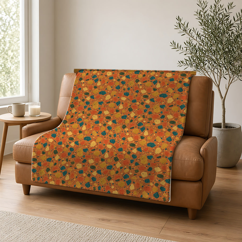 Macro Chip Mix Sherpa Fleece Blanket draped over a caramel leather sofa