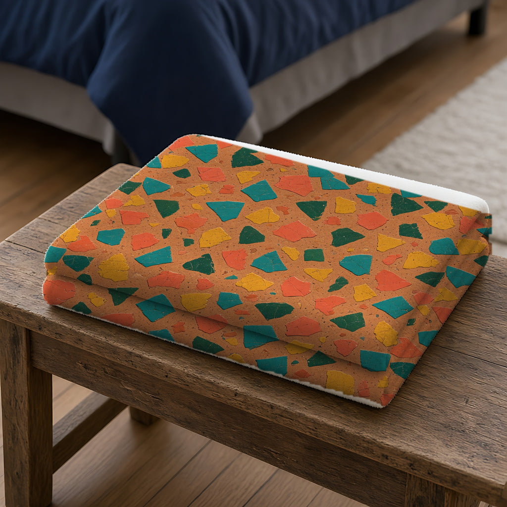 Shattered Tile Shards Sherpa Fleece Blanket folded on a wooden bench