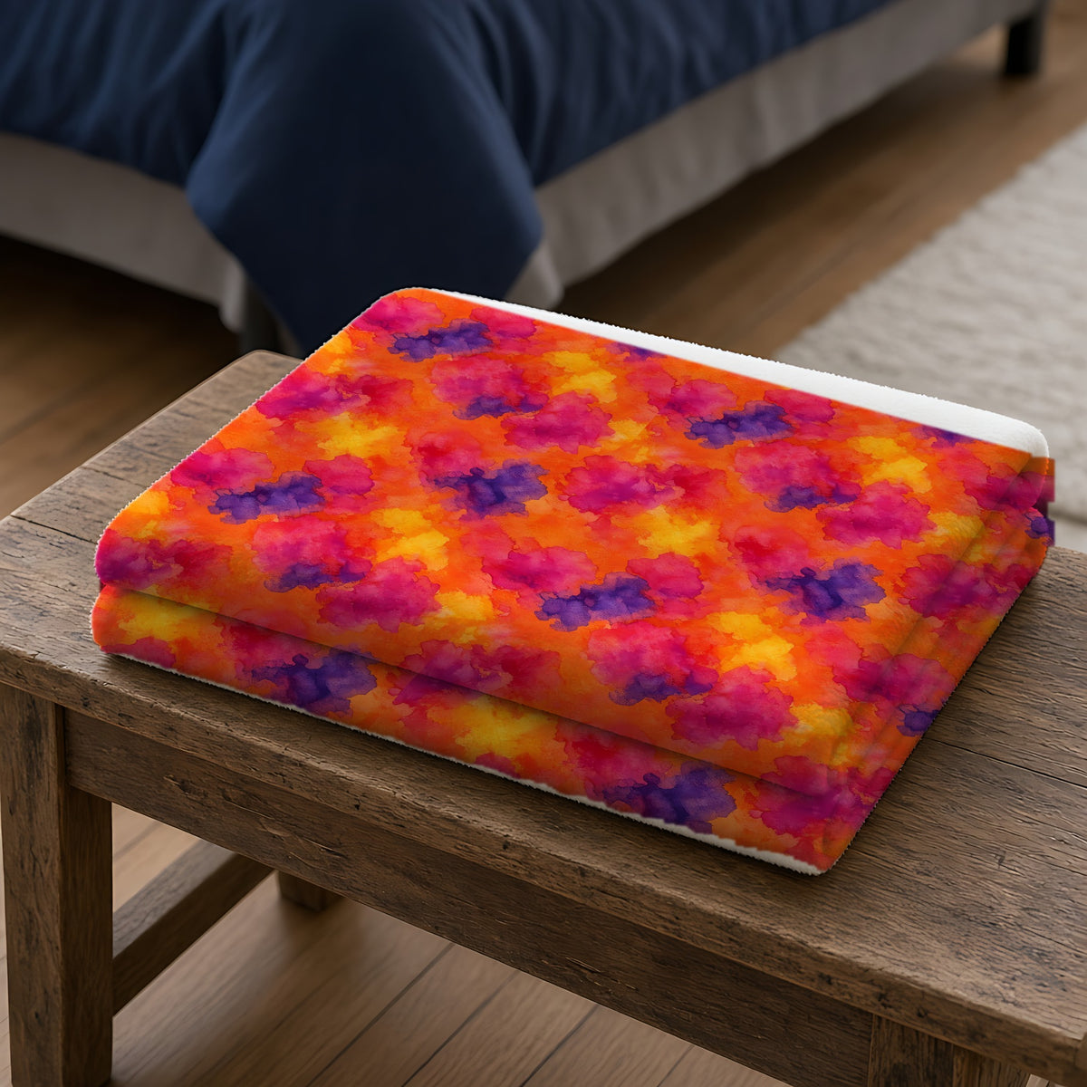 Sunset Bloom Bleeds Sherpa Fleece Blanket folded on a wooden bench