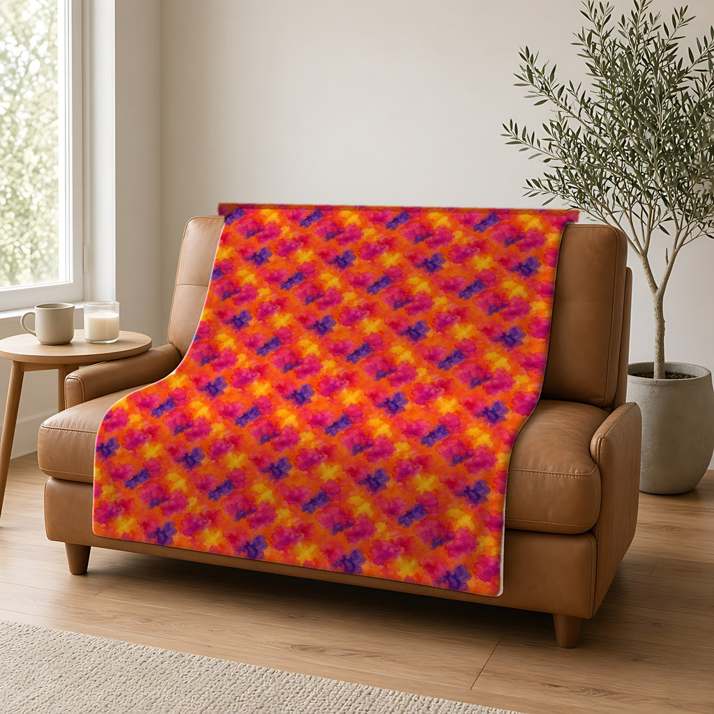 Sunset Bloom Bleeds Sherpa Fleece Blanket draped over a caramel leather sofa