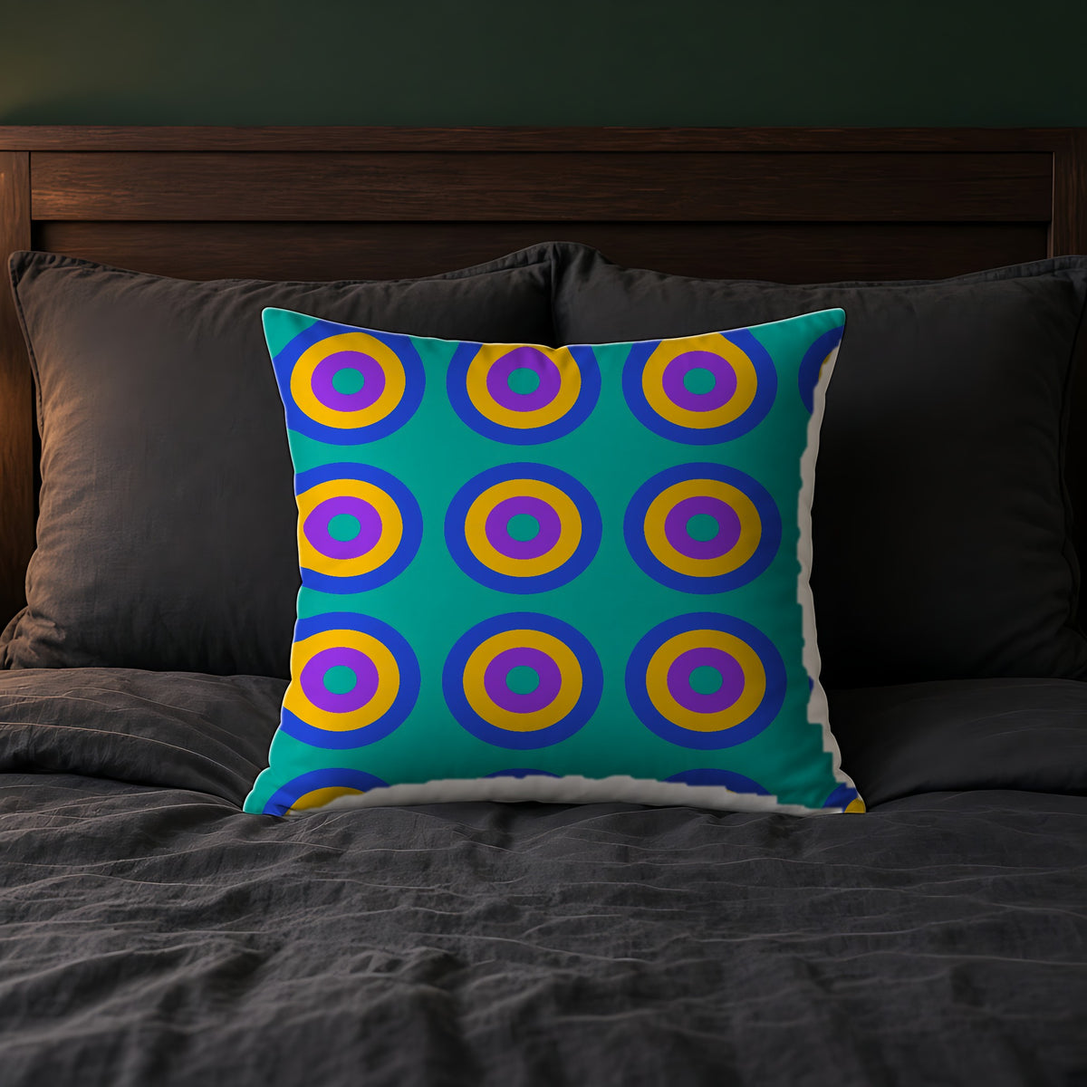 Giant Op-Art Jewel Rings Faux Suede Cushion on a bed with charcoal bedding