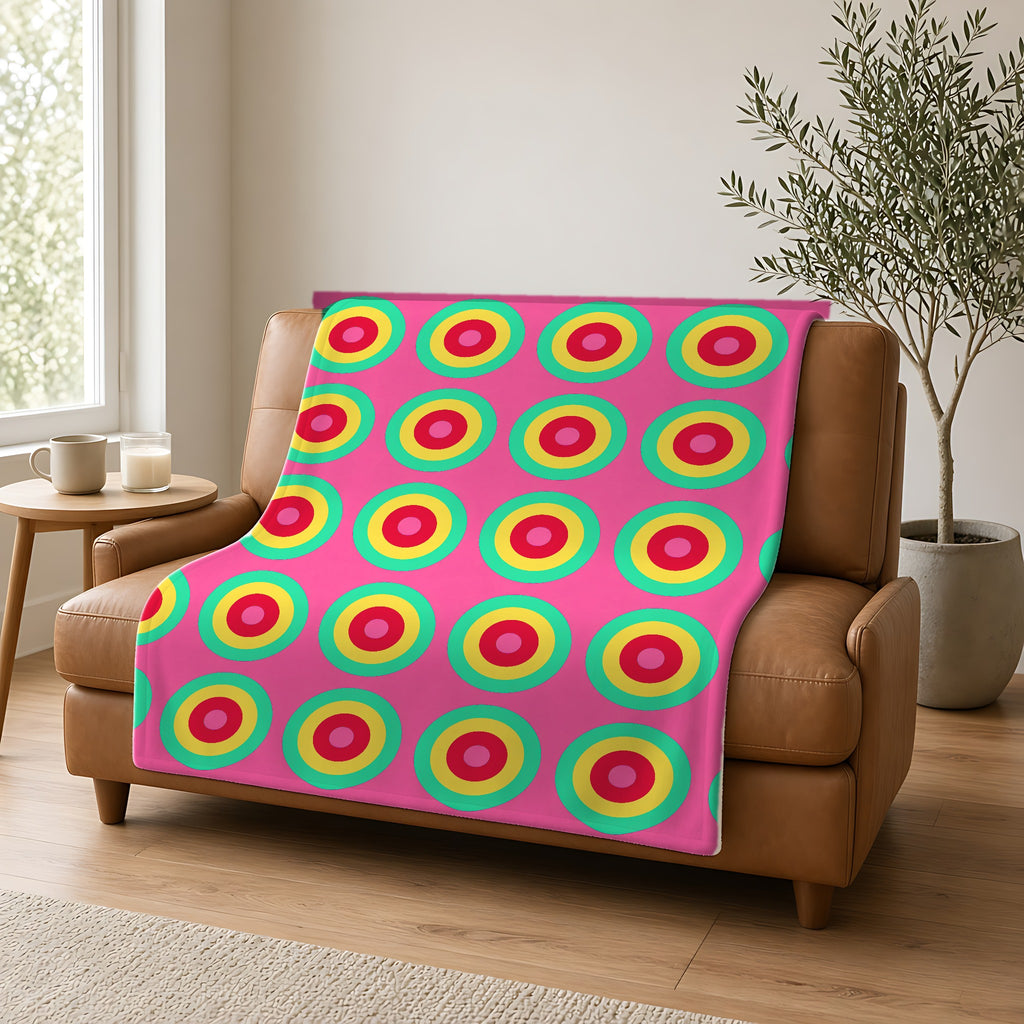 Giant Op-Art Jewel Rings Sherpa Fleece Blanket draped over a caramel leather sofa