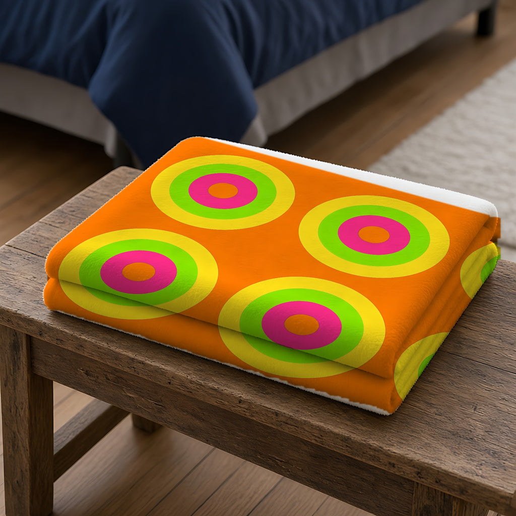 Giant Op-Art Jewel Rings Sherpa Fleece Blanket folded on a wooden bench