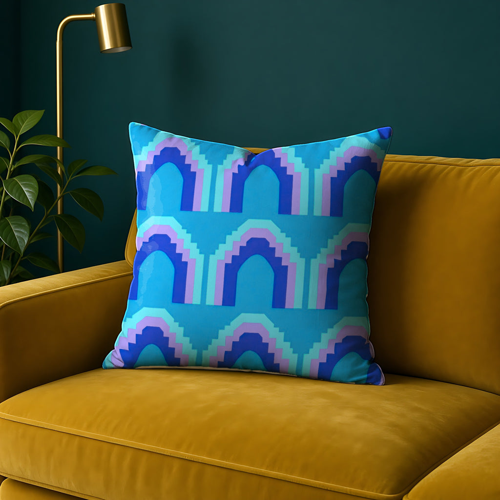 Grand Stepped Arches Faux Suede Cushion in the Ice Jewel palette, on a mustard sofa against a teal wall