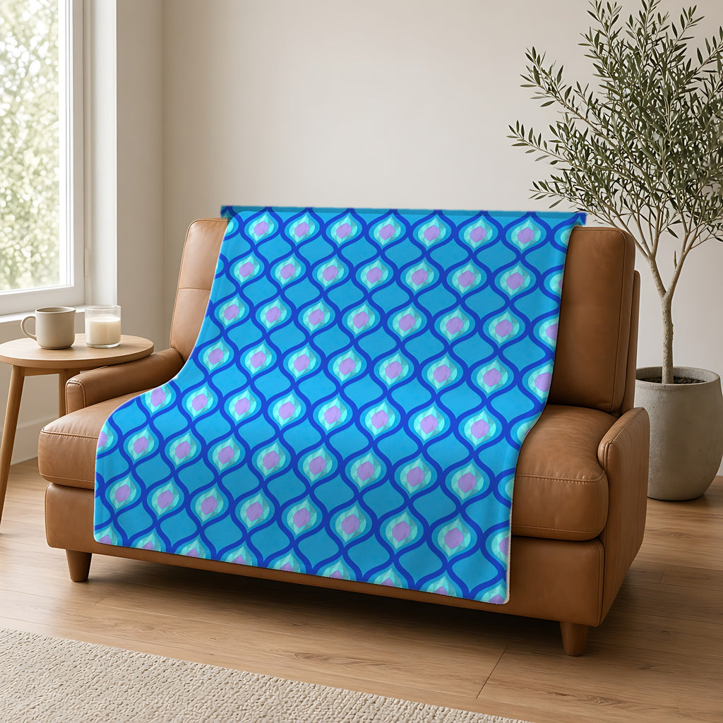 Grand Ogee Lattice II Sherpa Fleece Blanket draped over a caramel leather sofa