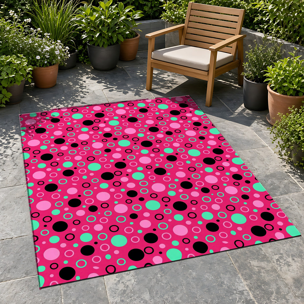 Bubble Outlines Outdoor Rug on a stone patio with potted plants