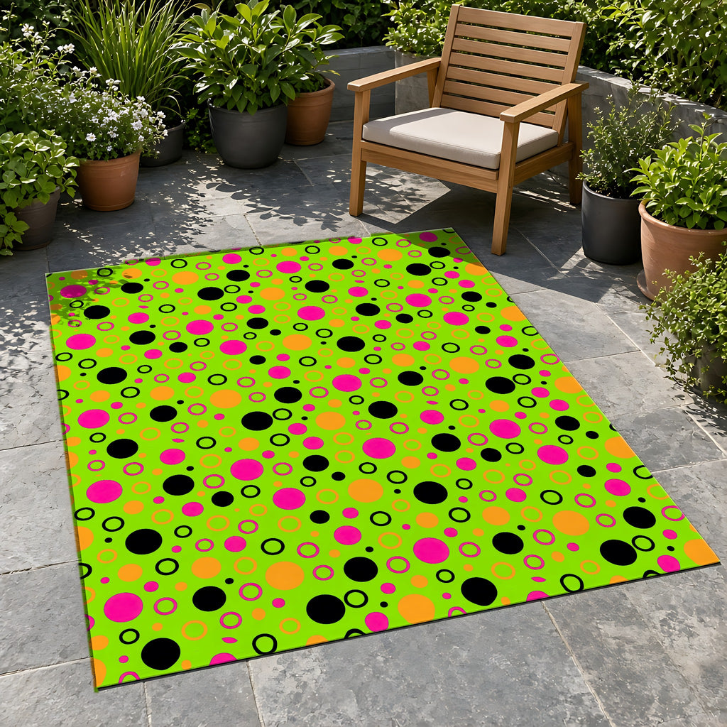Bubble Outlines Outdoor Rug on a stone patio with potted plants
