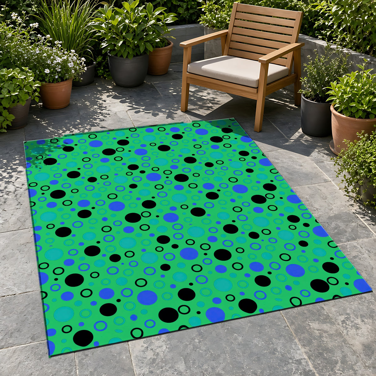 Bubble Outlines Outdoor Rug on a stone patio with potted plants