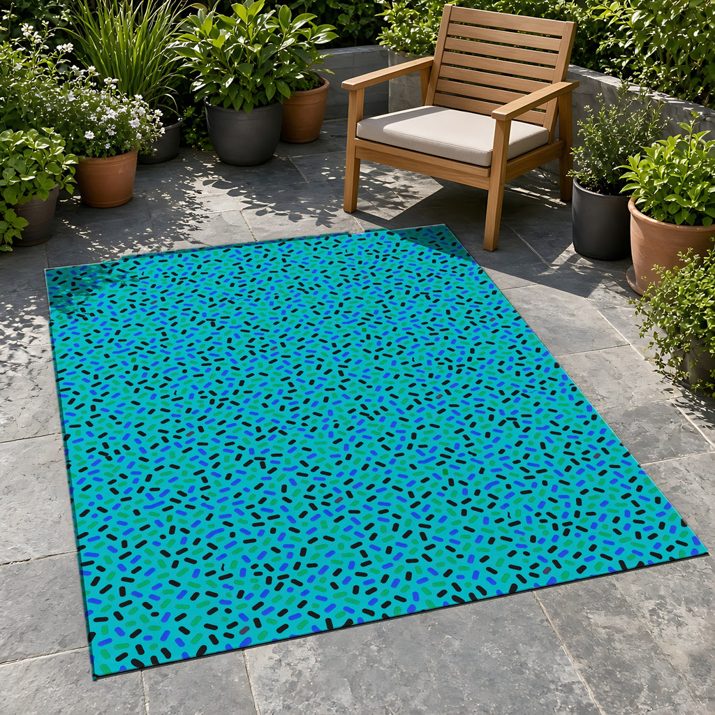 Sprinkle Pop Outdoor Rug on a stone patio with potted plants