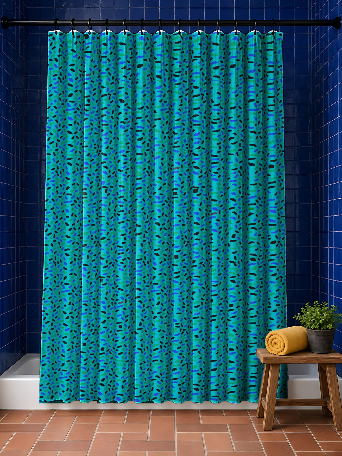 Sprinkle Pop Shower Curtain in the Peacock Jewel palette, hanging in a bathroom with cobalt tiles and a terracotta floor