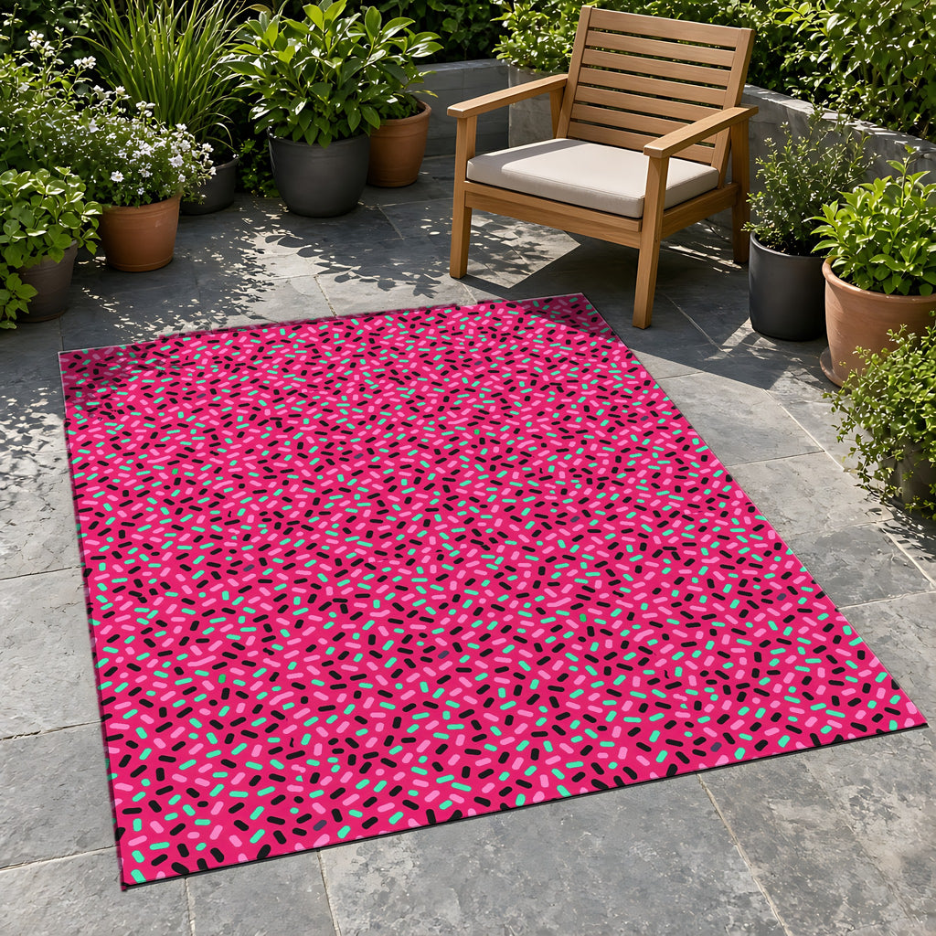 Sprinkle Pop Outdoor Rug on a stone patio with potted plants