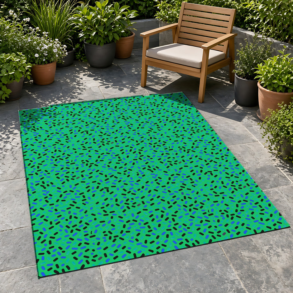 Sprinkle Pop Outdoor Rug on a stone patio with potted plants