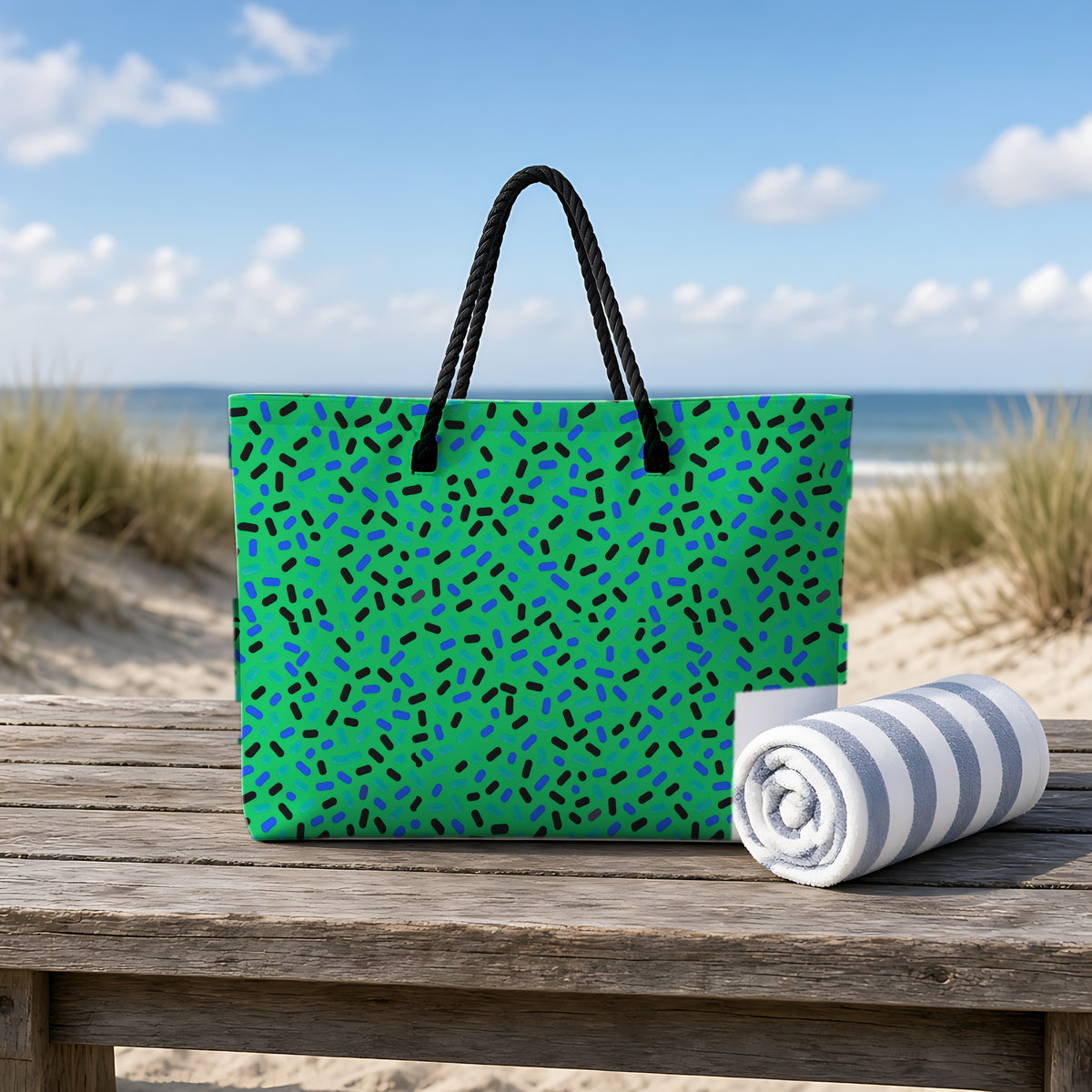 Sprinkle Pop Weekender Tote Bag on a rustic table by the beach