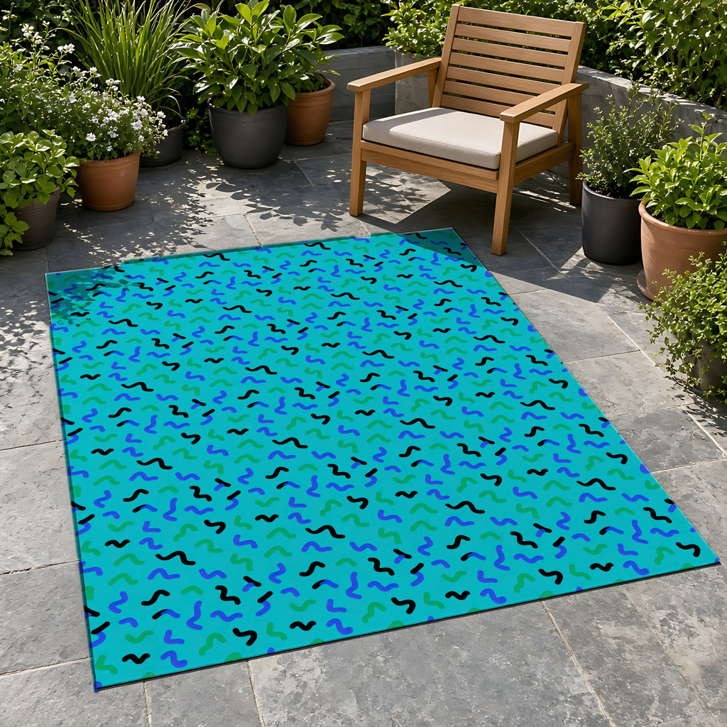 Squiggle Strokes Outdoor Rug on a stone patio with potted plants