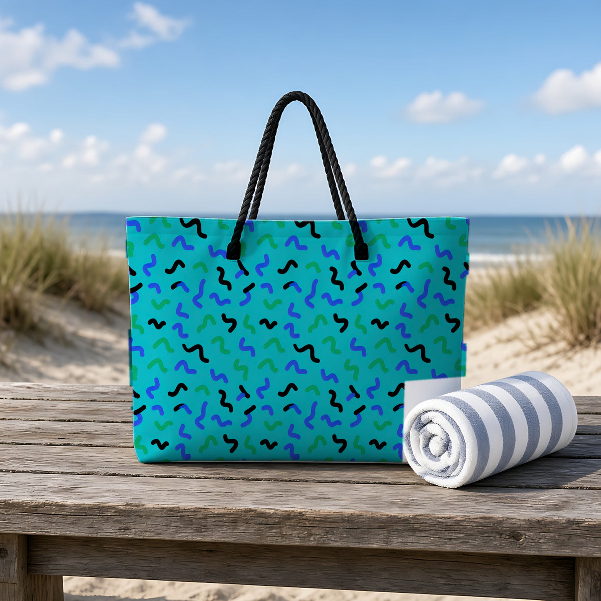 Squiggle Strokes Weekender Tote Bag on a rustic table by the beach