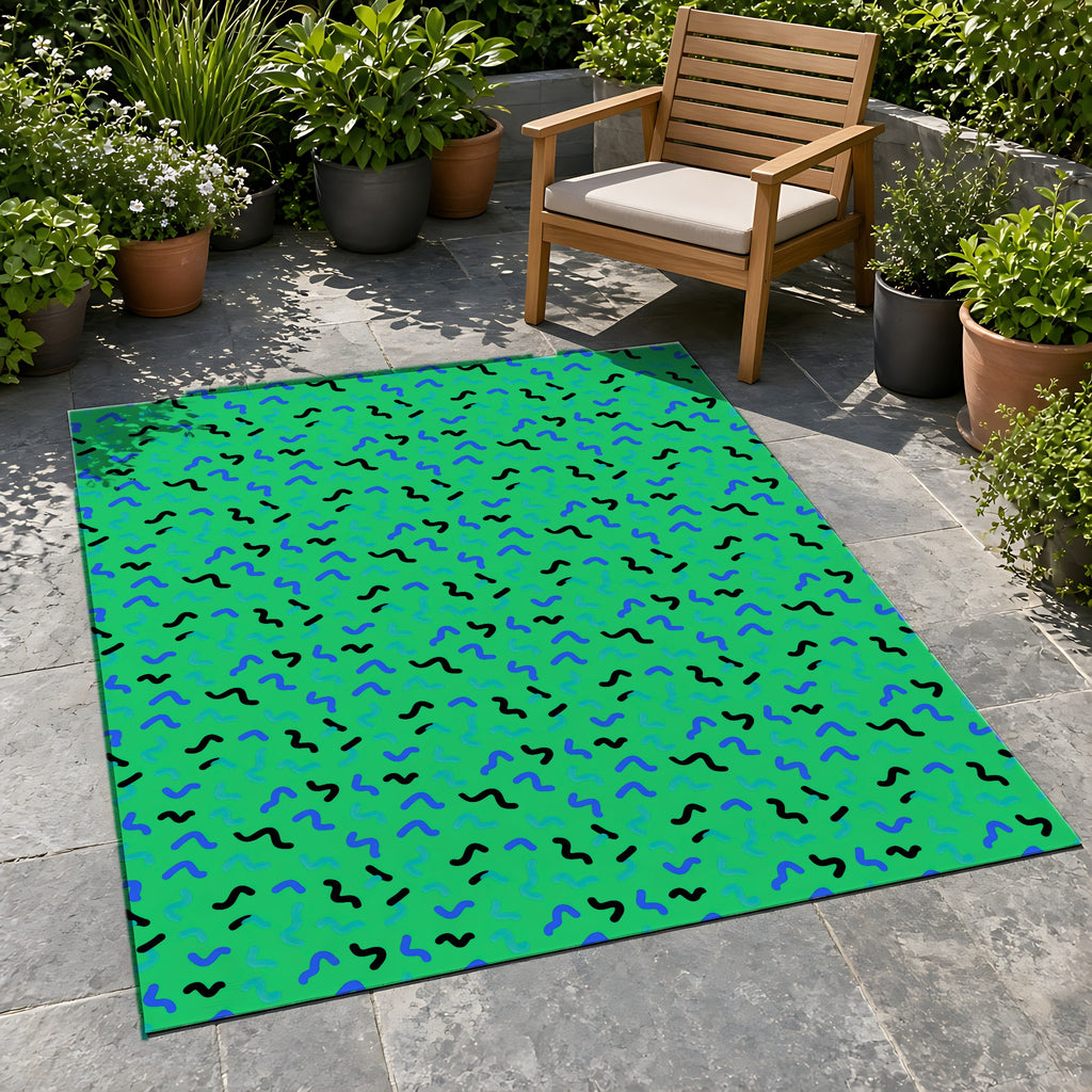 Squiggle Strokes Outdoor Rug on a stone patio with potted plants