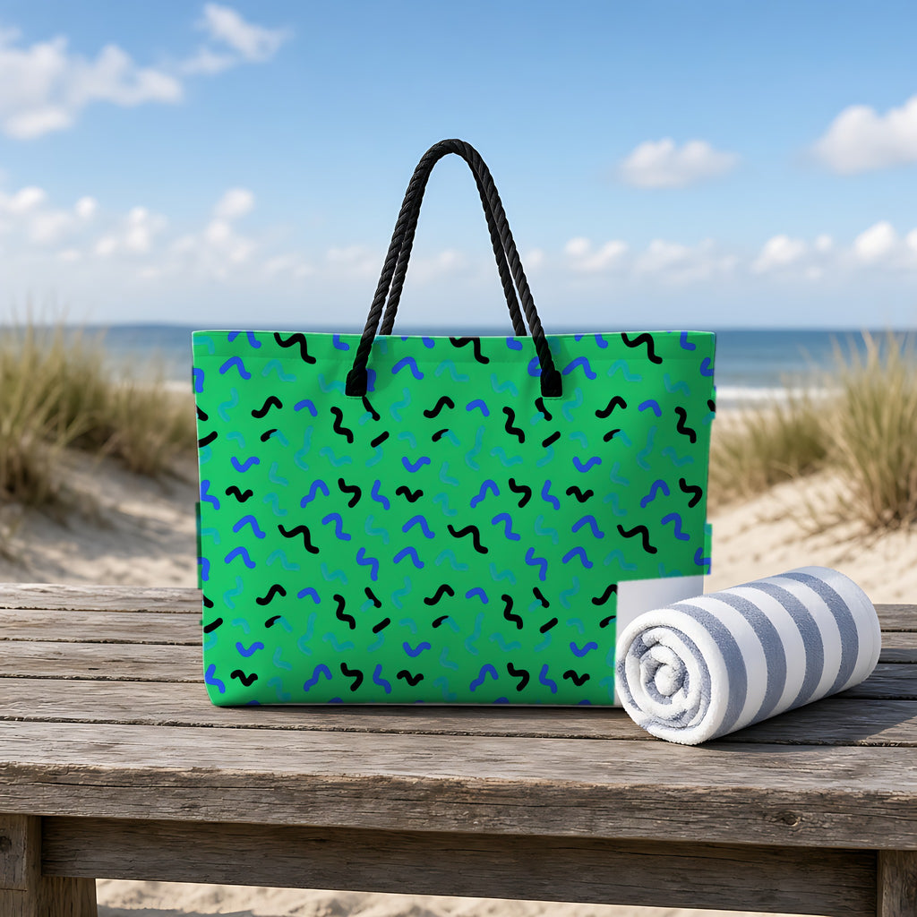 Squiggle Strokes Weekender Tote Bag on a rustic table by the beach