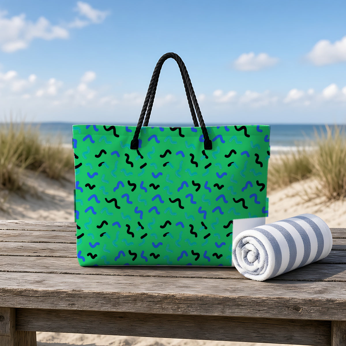 Squiggle Strokes Weekender Tote Bag on a rustic table by the beach