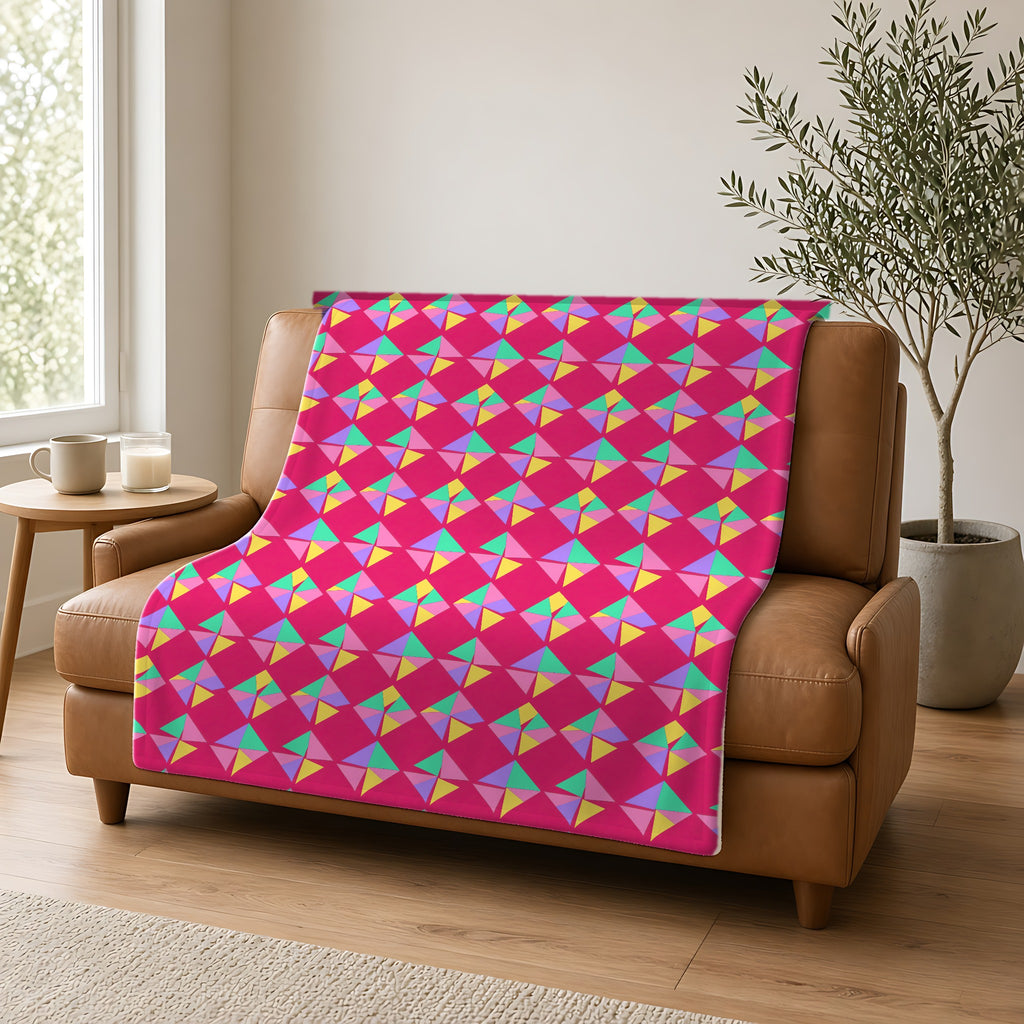 Stacked Cubist Prisms Sherpa Fleece Blanket draped over a caramel leather sofa