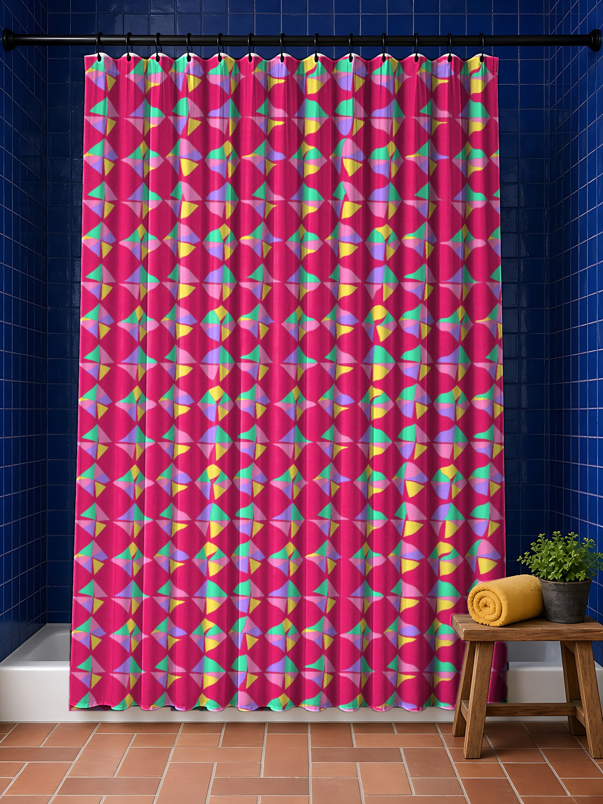 Stacked Cubist Prisms Shower Curtain in the Candy Pop on Raspberry palette, hanging in a bathroom with cobalt tiles and a terracotta floor