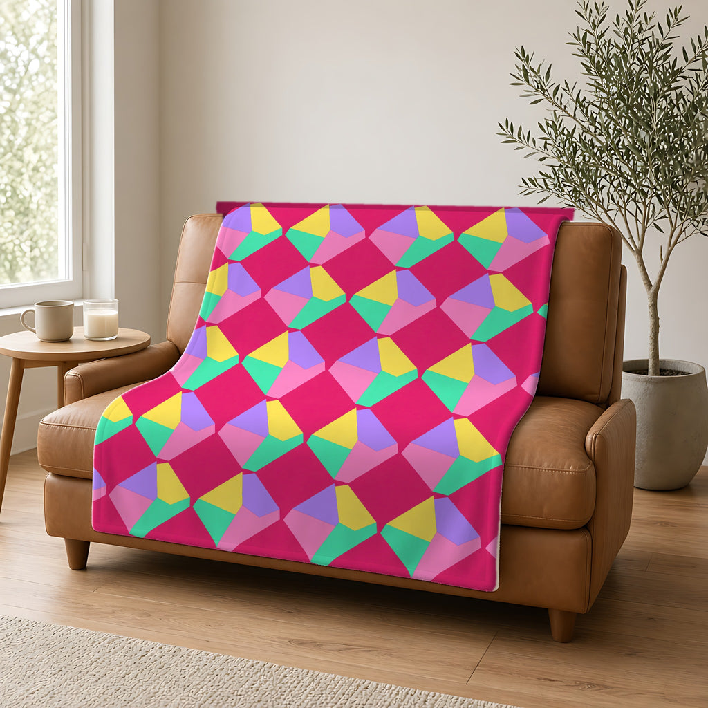Grand Fractured Rhombus Sherpa Fleece Blanket draped over a caramel leather sofa