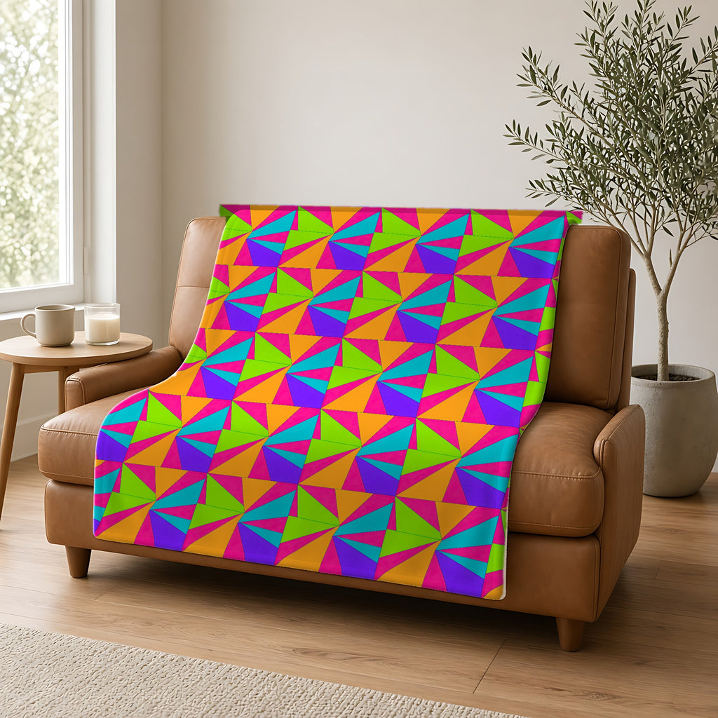 Cubist Sunburst Blocks Sherpa Fleece Blanket draped over a caramel leather sofa