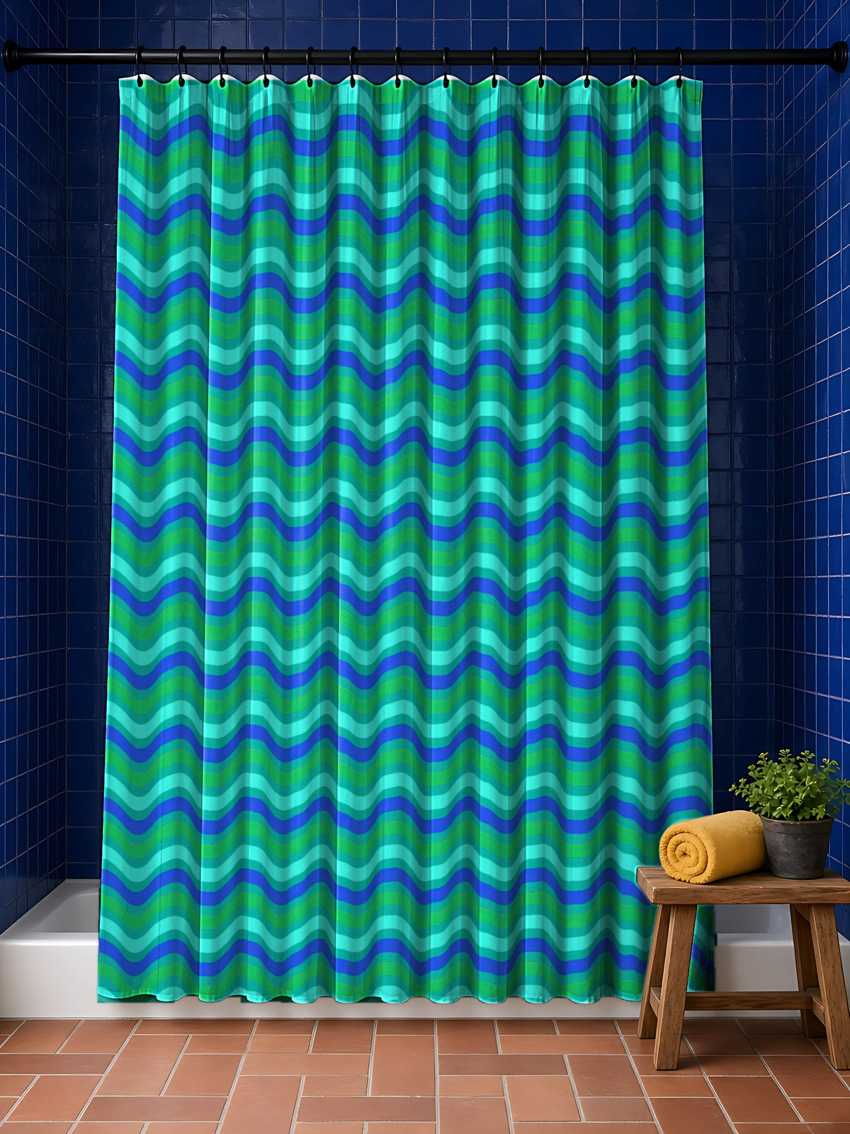 Wide Wave Interference Shower Curtain in the Ocean Jewel palette, hanging in a bathroom with cobalt tiles and a terracotta floor