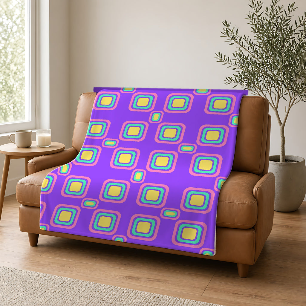 Big Ripple Squares Sherpa Fleece Blanket draped over a caramel leather sofa