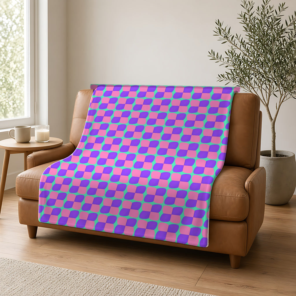 Bold Bulge Checker Sherpa Fleece Blanket draped over a caramel leather sofa