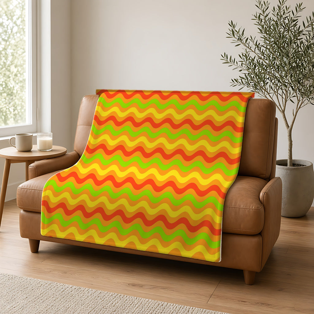 Big Ripple Chevrons Sherpa Fleece Blanket draped over a caramel leather sofa