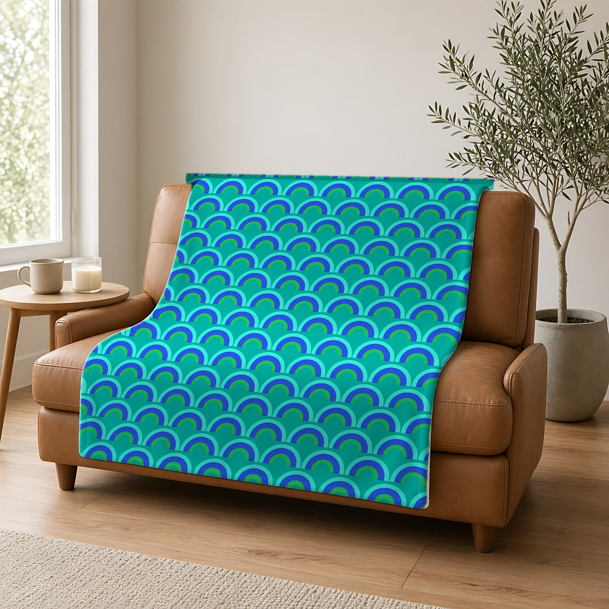 Chromatic Scallop Ripple Sherpa Fleece Blanket draped over a caramel leather sofa