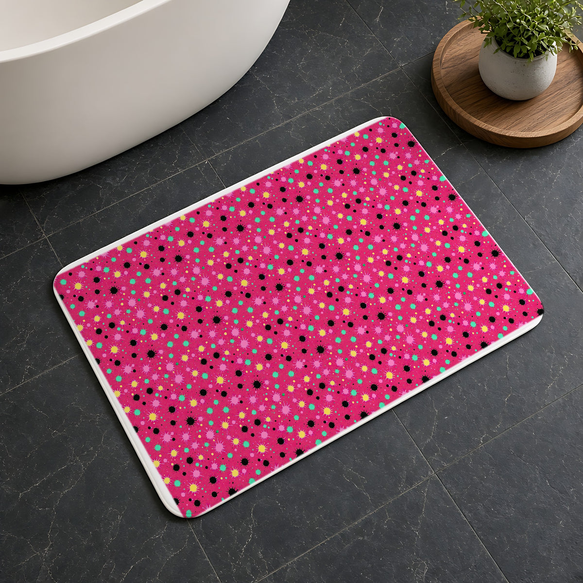 Splat Storm Bath Mat on a dark slate floor beside a bath