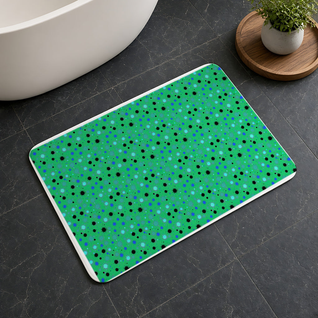 Splat Storm Bath Mat on a dark slate floor beside a bath