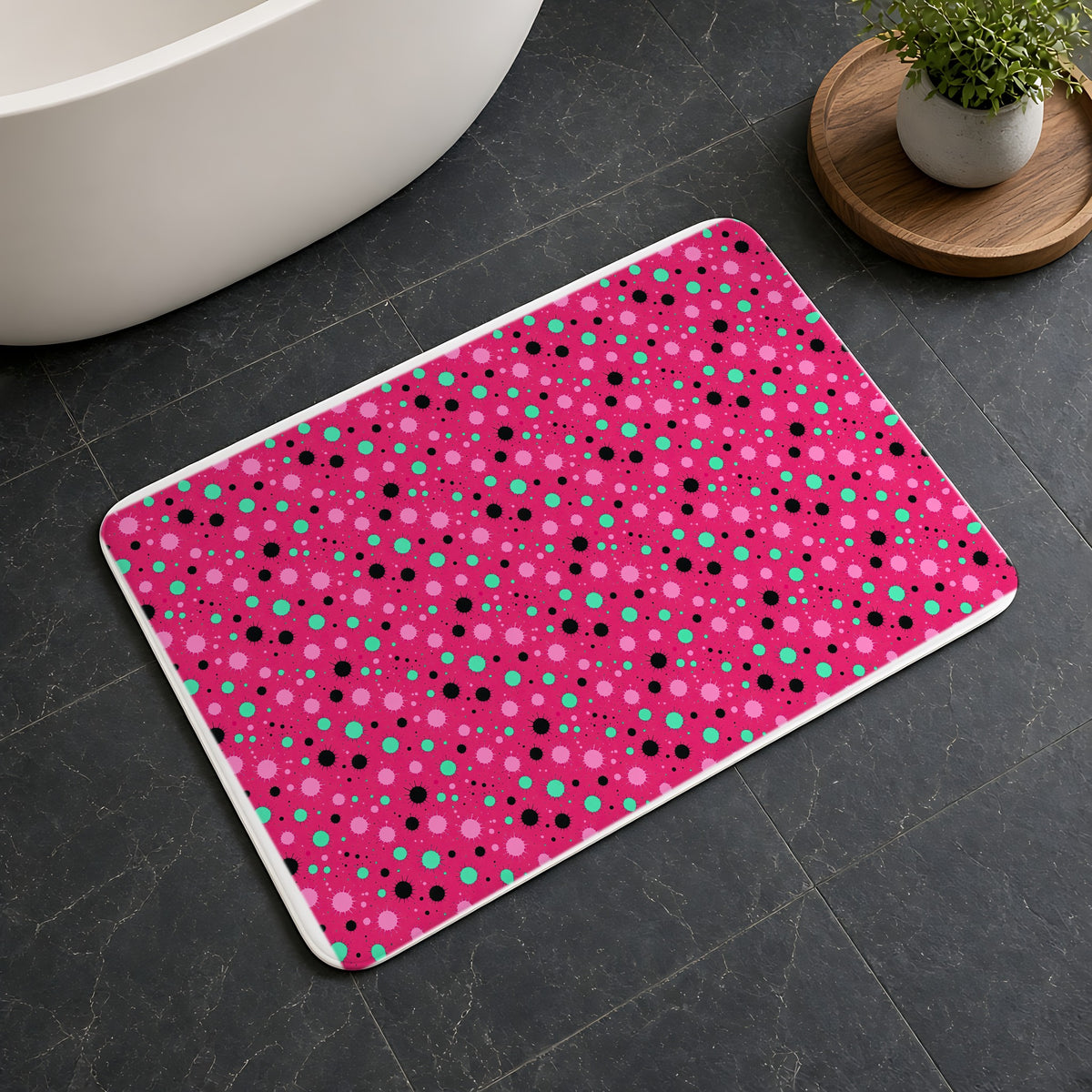 Blot Burst Bath Mat on a dark slate floor beside a bath