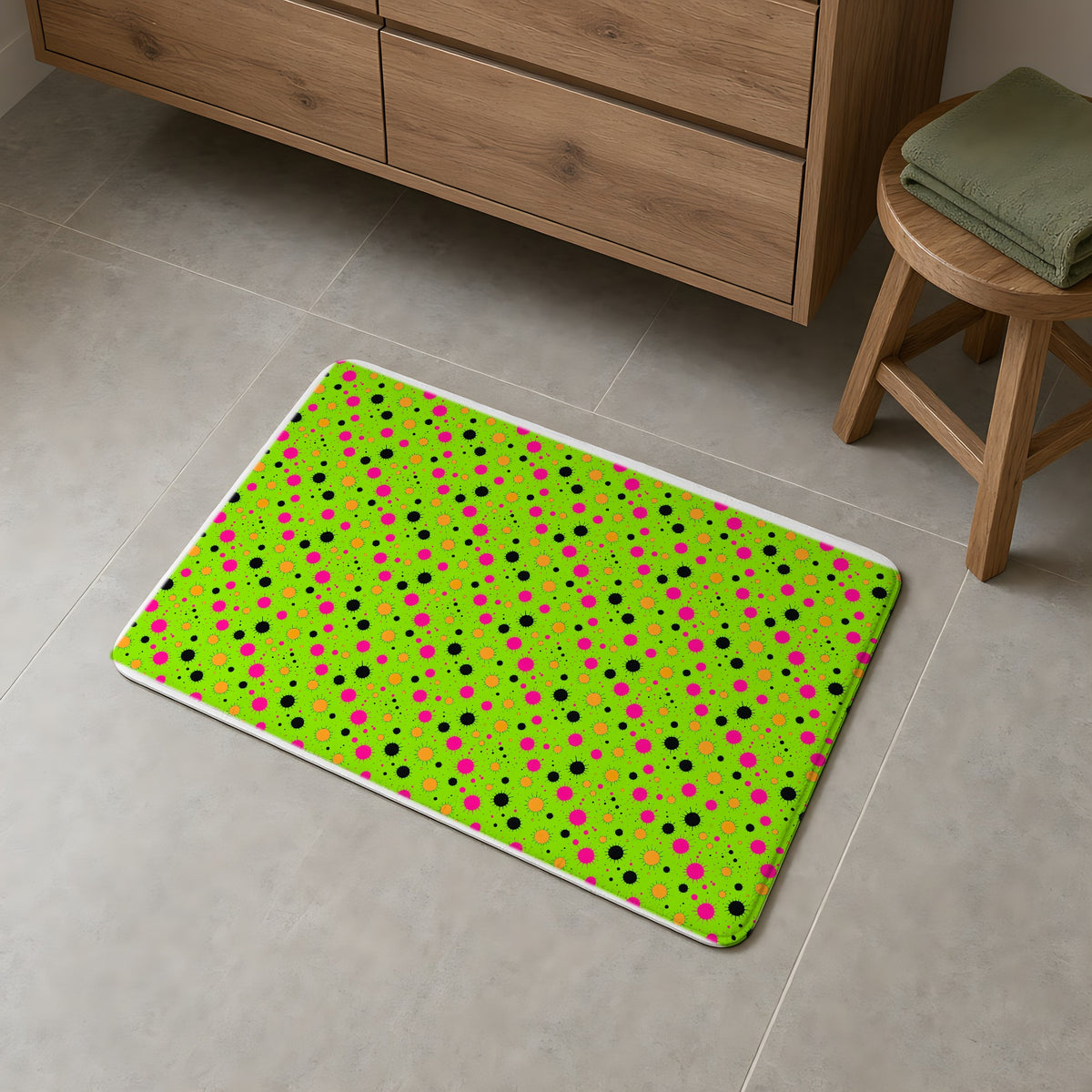 Blot Burst Bath Mat on a grey tiled bathroom floor