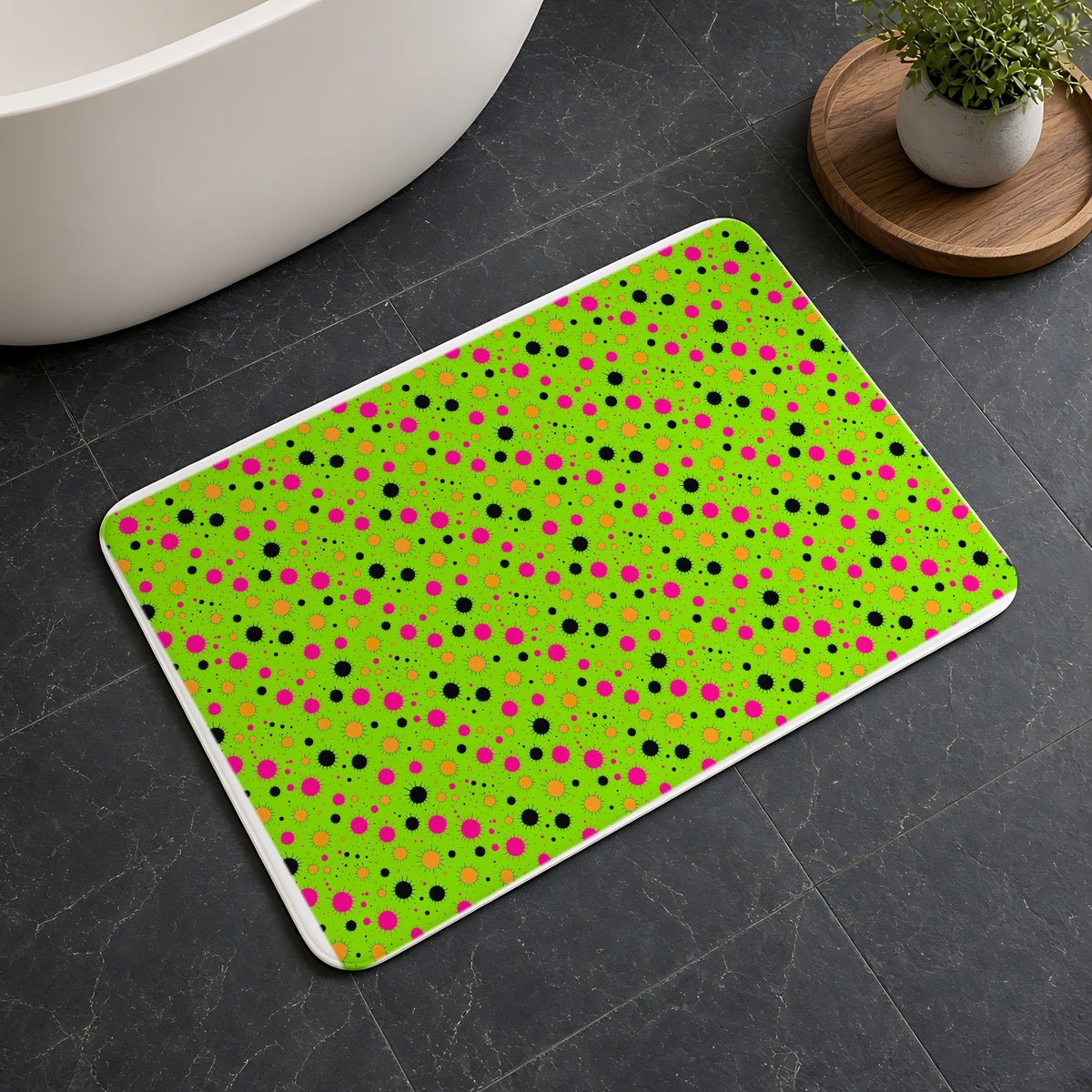 Blot Burst Bath Mat on a dark slate floor beside a bath