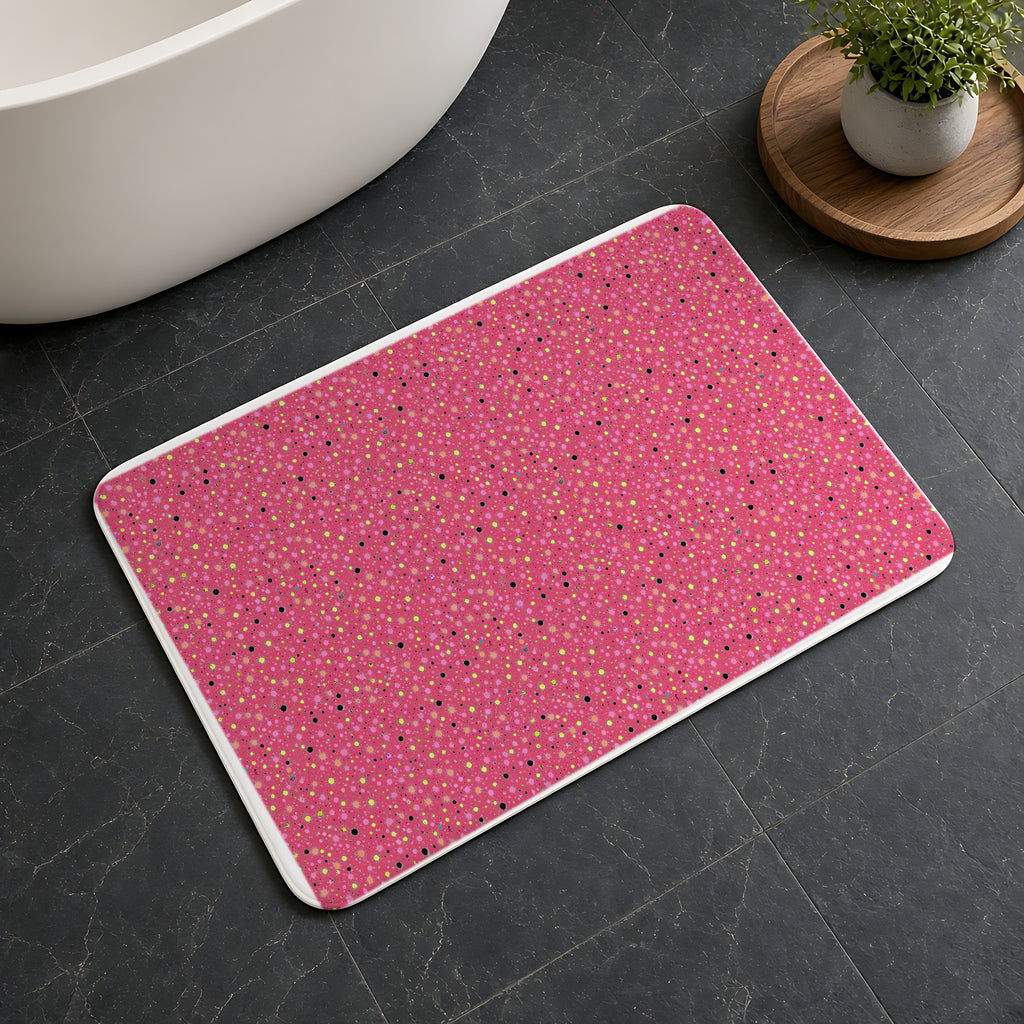 Confetti Spatter Bath Mat on a dark slate floor beside a bath