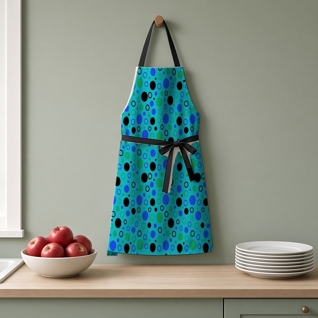 Bubble Outlines Apron hanging on a sage-green kitchen wall