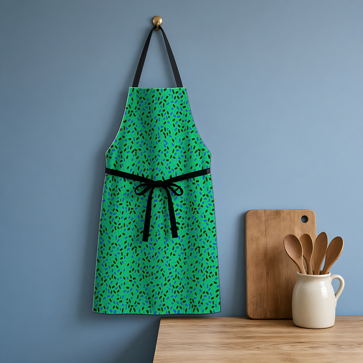 Sprinkle Pop Apron hanging in a blue kitchen