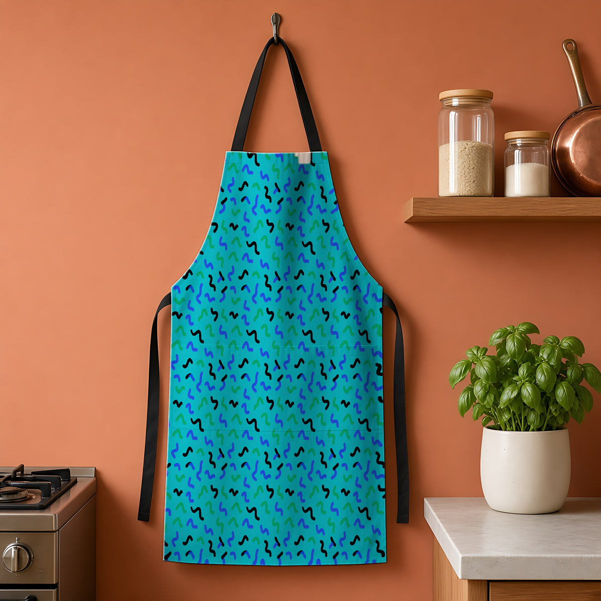 Squiggle Strokes Apron hanging on a terracotta kitchen wall