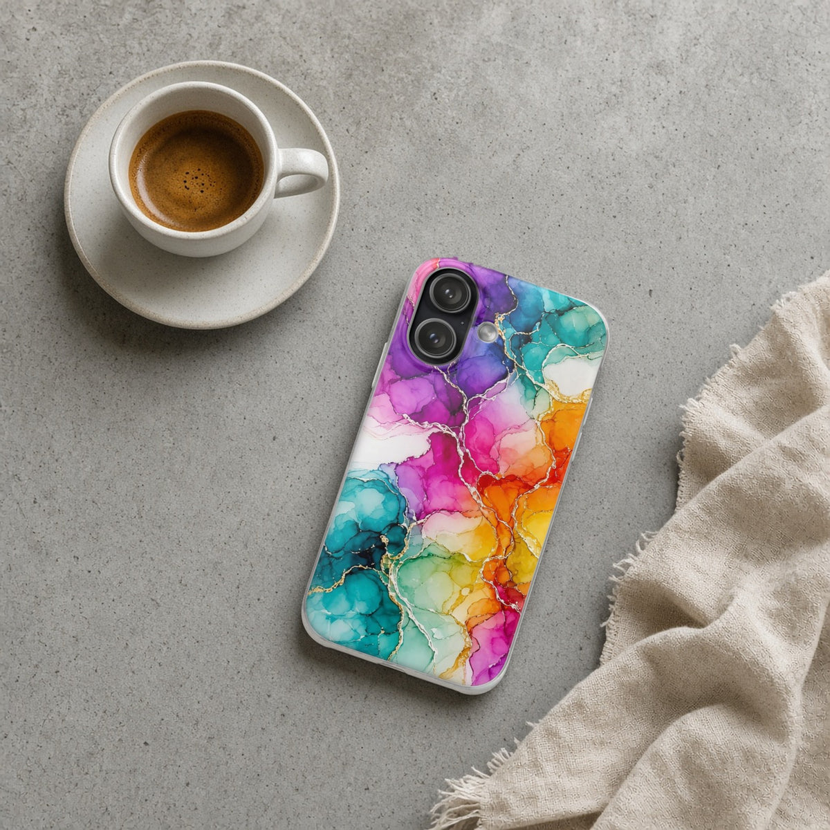 Rainbow Alcohol Ink Bloom flexi phone case on a concrete cafe table with an espresso
