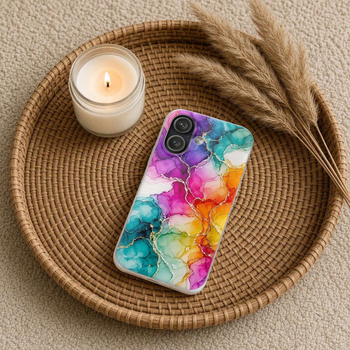 Rainbow Alcohol Ink Bloom flexi phone case on a rattan tray with a candle and dried grasses