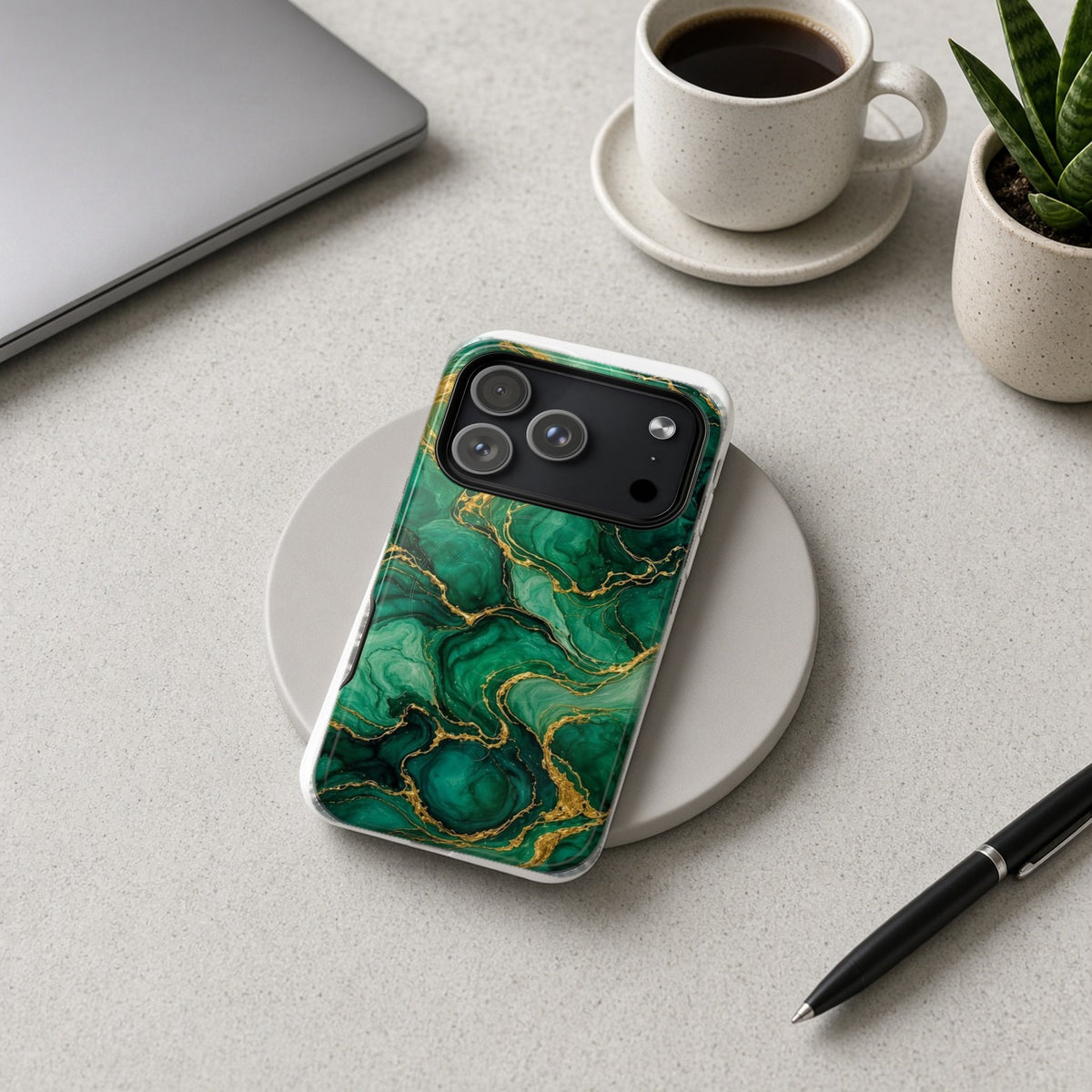 Emerald Tide-Pool Pour magnetic iPhone case on a wireless charging pad on a grey desk