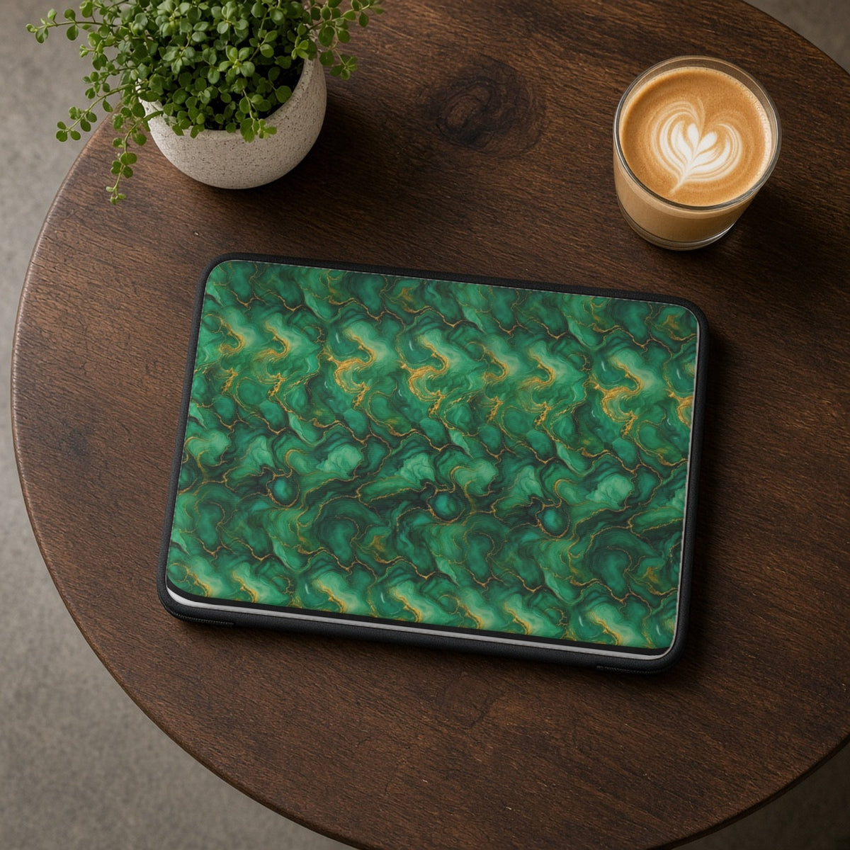 Emerald Tide-Pool Pour laptop sleeve on a round wooden cafe table with a latte