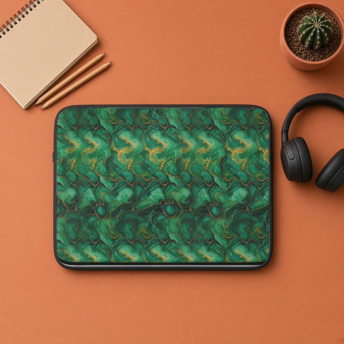 Emerald Tide-Pool Pour laptop sleeve flat lay on terracotta with headphones and a notebook