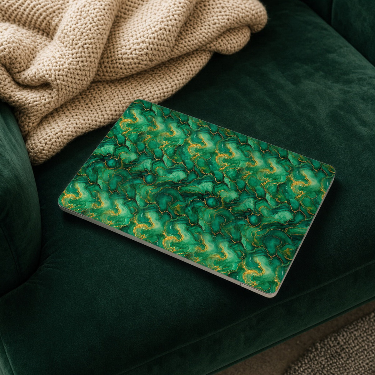 Emerald Tide-Pool Pour matte MacBook case on a laptop resting on a green velvet sofa