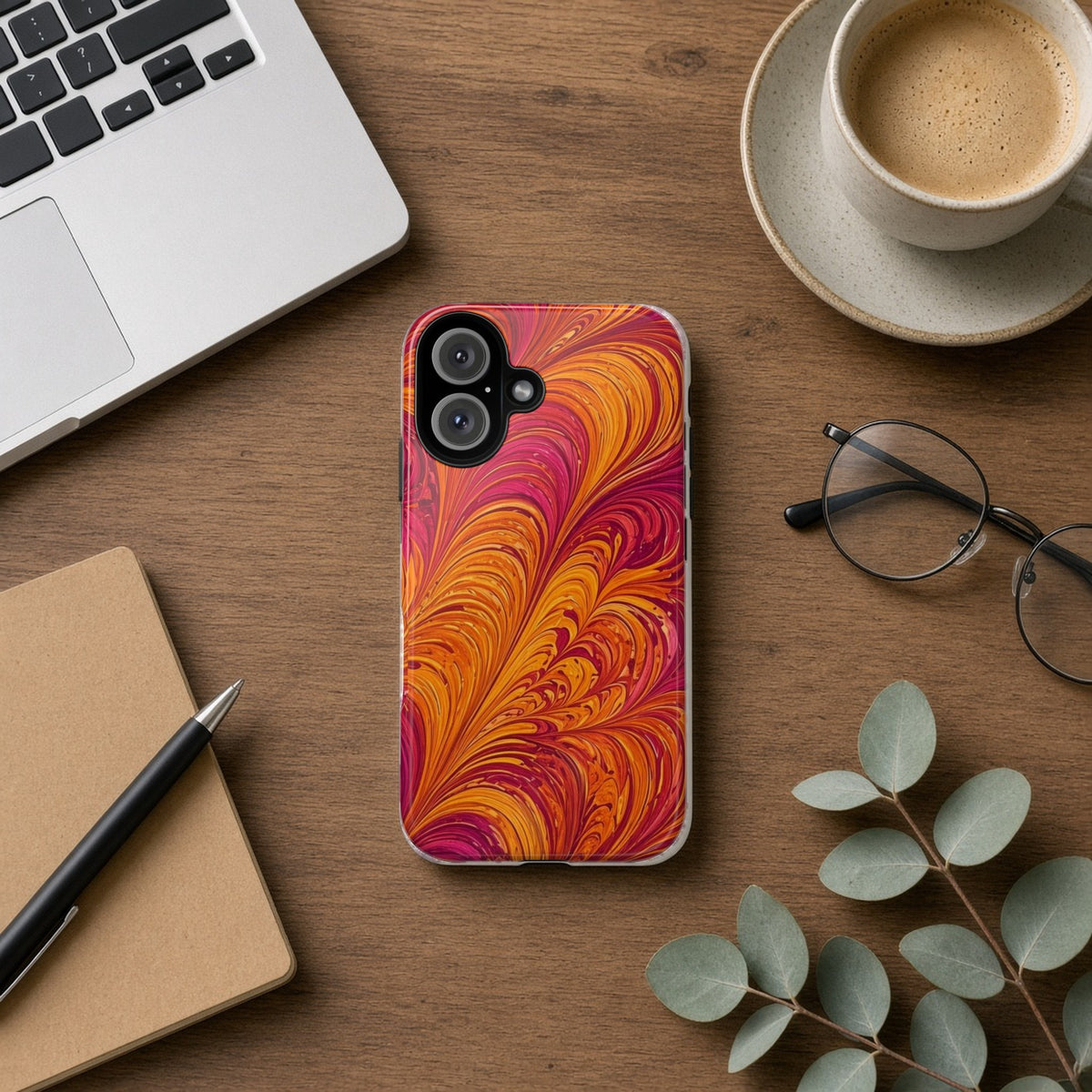 Sunset Feather Marbling tough phone case on a wooden desk beside a laptop, coffee and eucalyptus